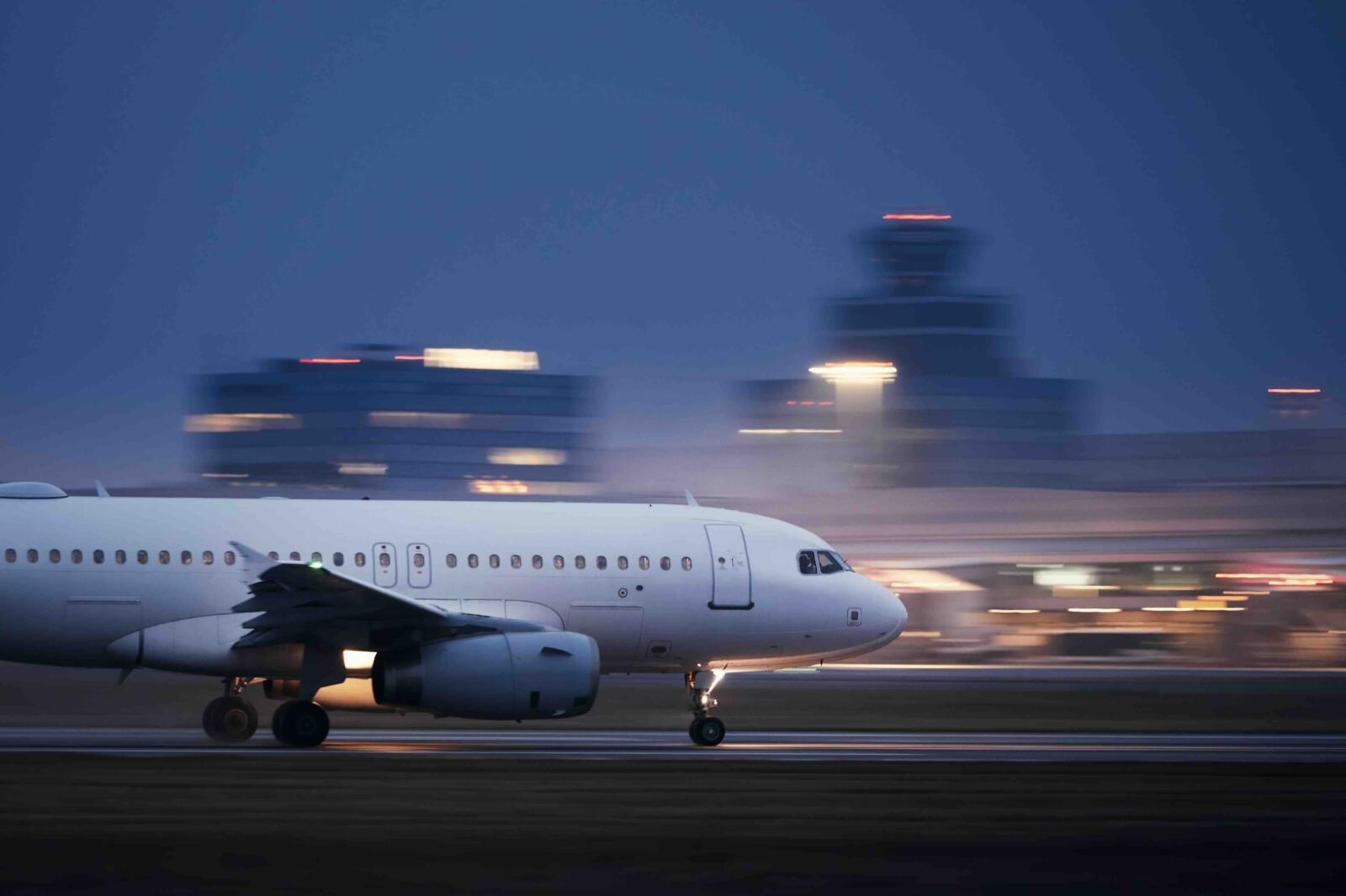 airplane-take-off-airport-runway-night-against-air-traffic-control-tower