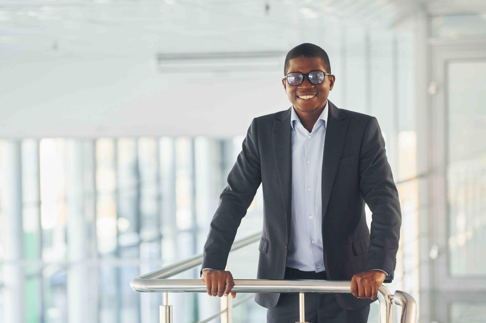 leaning-railings-young-african-american-businessman-black-suit-is-indoors